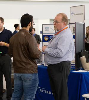 A student speaks with a representative from Lockeed Martin at the Career Fair